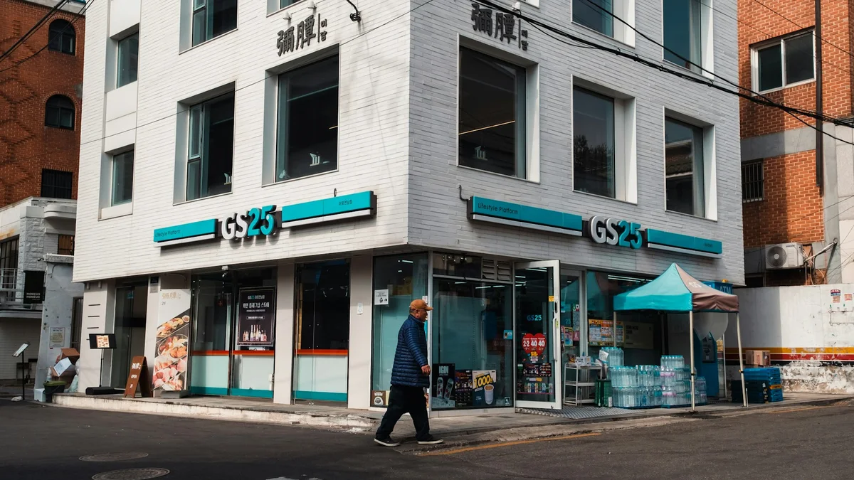 A pedestrian walking past a Korean convenience store