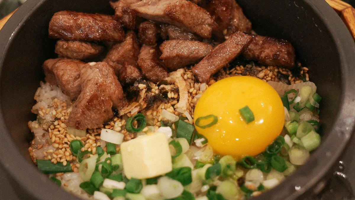 Korean bibimbap topped with an egg and meat