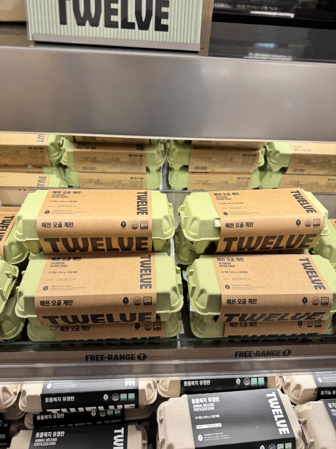 TWELVE-branded egg cartons on a refrigerated shelf. TWELVE-branded egg cartons on a refrigerated shelf.