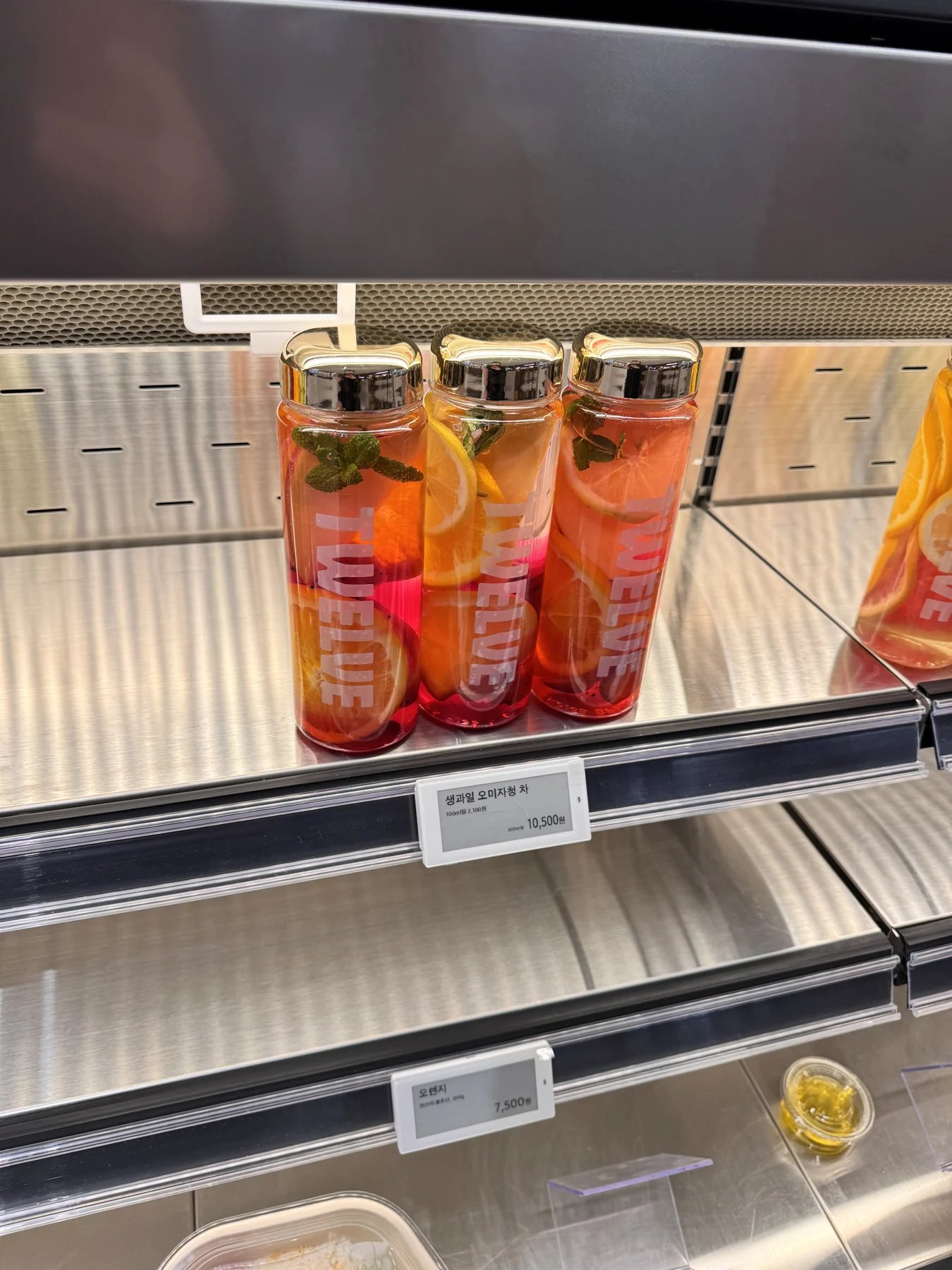 Fruit-filled bottled drinks in a refrigerated display. Fruit-filled bottled drinks in a refrigerated display.